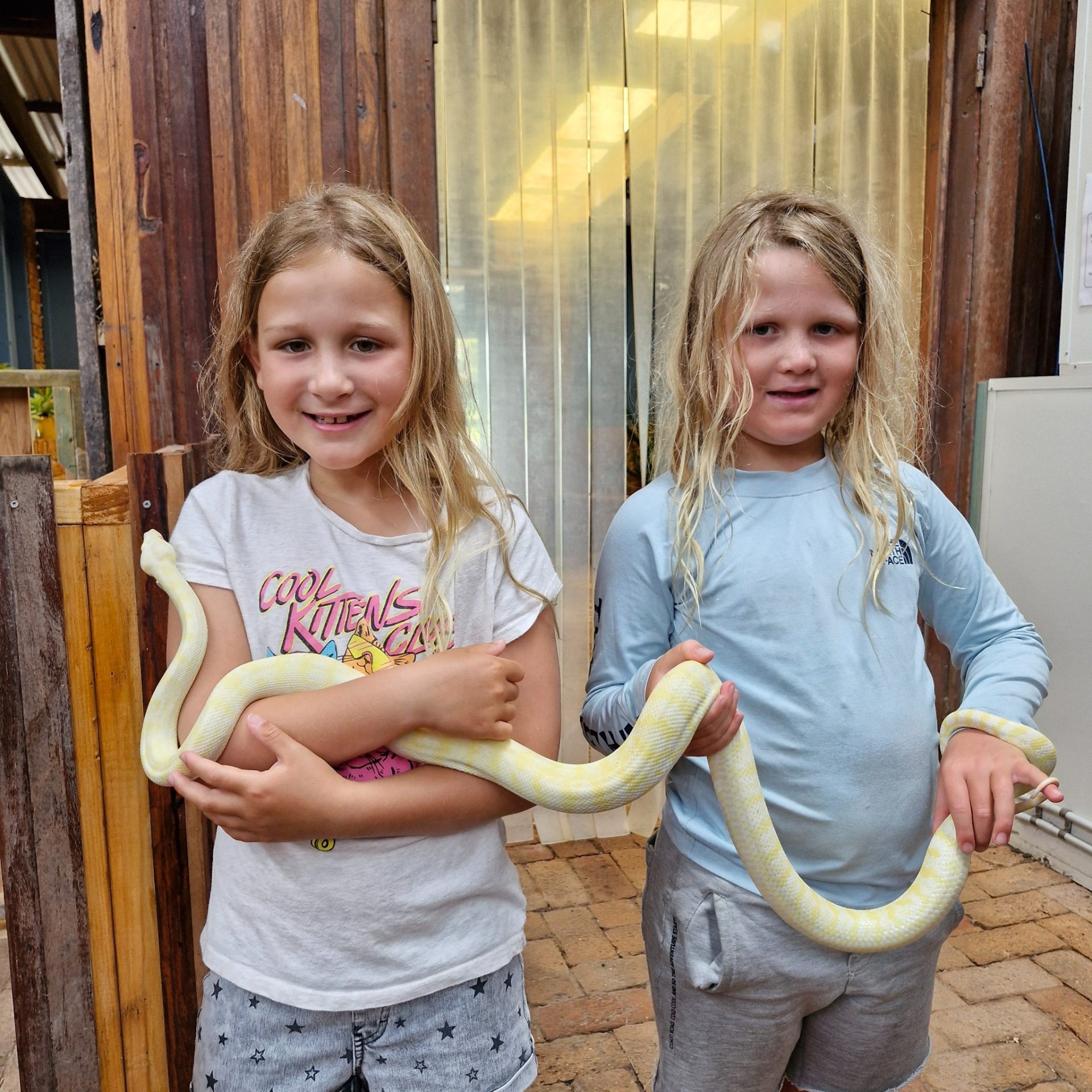 Two students holding a python during a keeper encounter